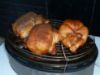 Three chickens roasting on Cobb Supreme portable charcoal cooker