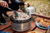 Sausages frying in the Cobb cooker on garden decking