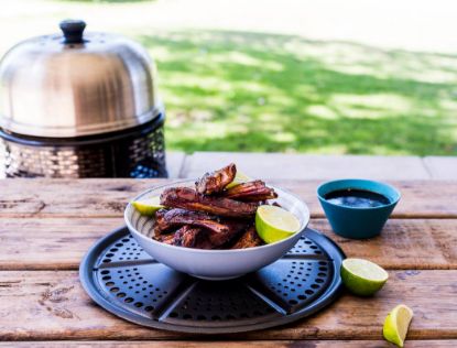 Cooked ribs in a bowl on a park bench with the Cobb PRO